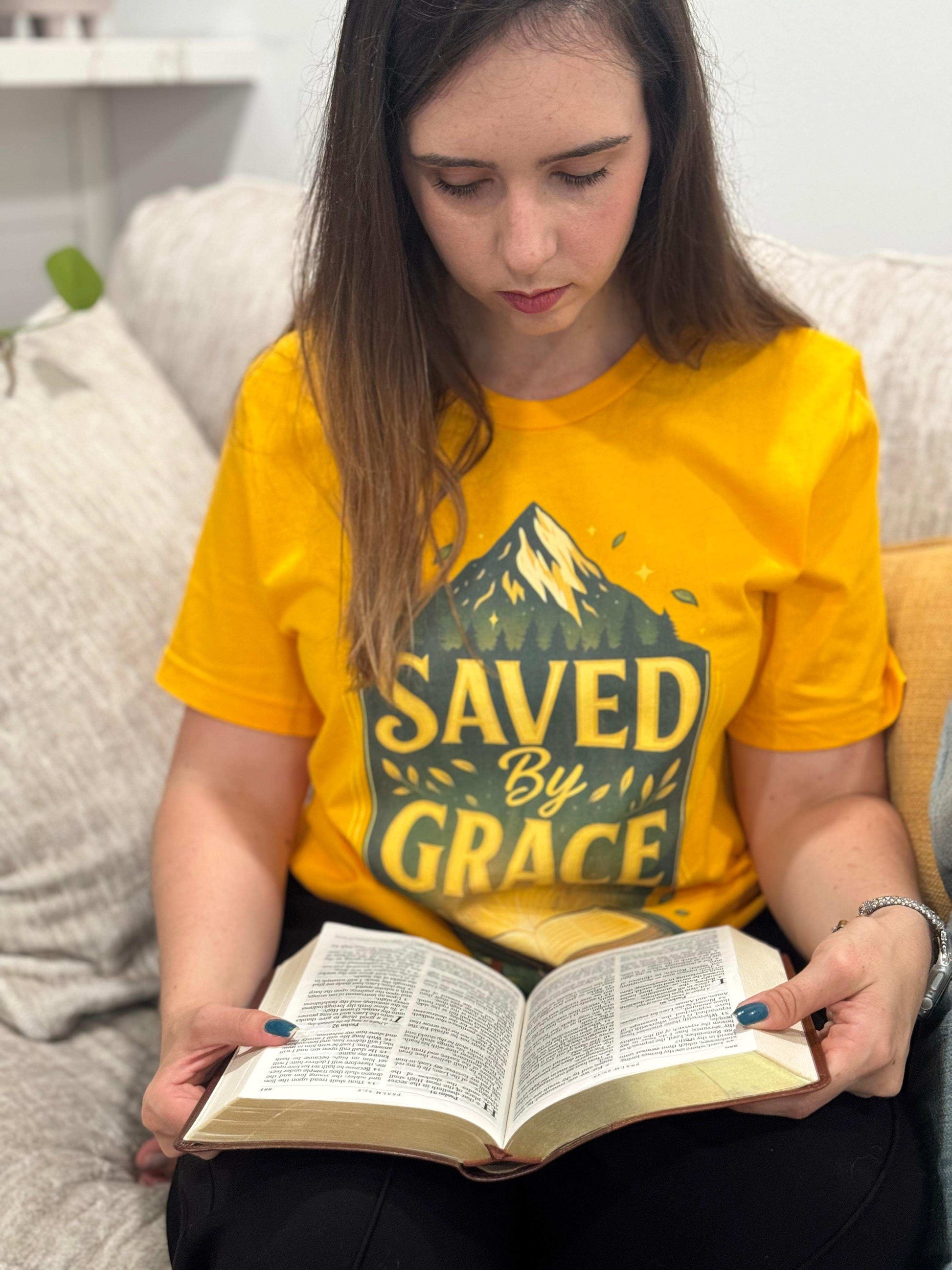 Religious t-shirt with a powerful "Saved by Grace" design and Bible illustration