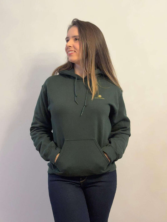 Woman wearing a green hoodie with a logo on a plain background