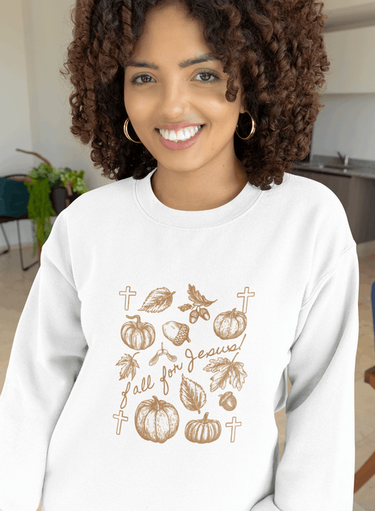 Woman wearing a white sweatshirt with fall-themed designs in a kitchen setting