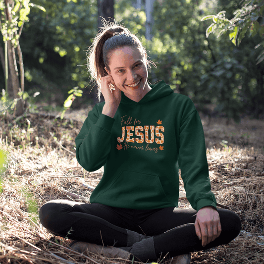 Person wearing a green hoodie with 'Fall for Jesus' text, sitting in a natural setting.