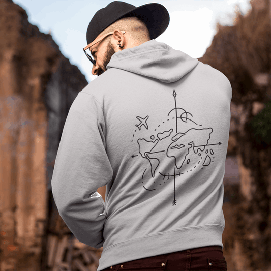 Man wearing a gray hoodie with a world map design outdoors