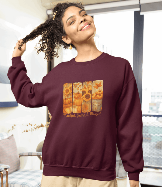 Woman wearing a maroon sweatshirt with a colorful design and text, standing in a room with a couch and rug.
