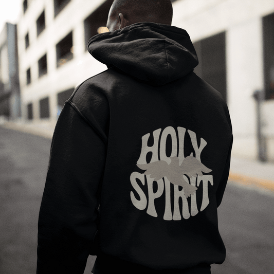 Person wearing a black hoodie with 'Holy Spirit' printed on the back, standing on an urban street.
