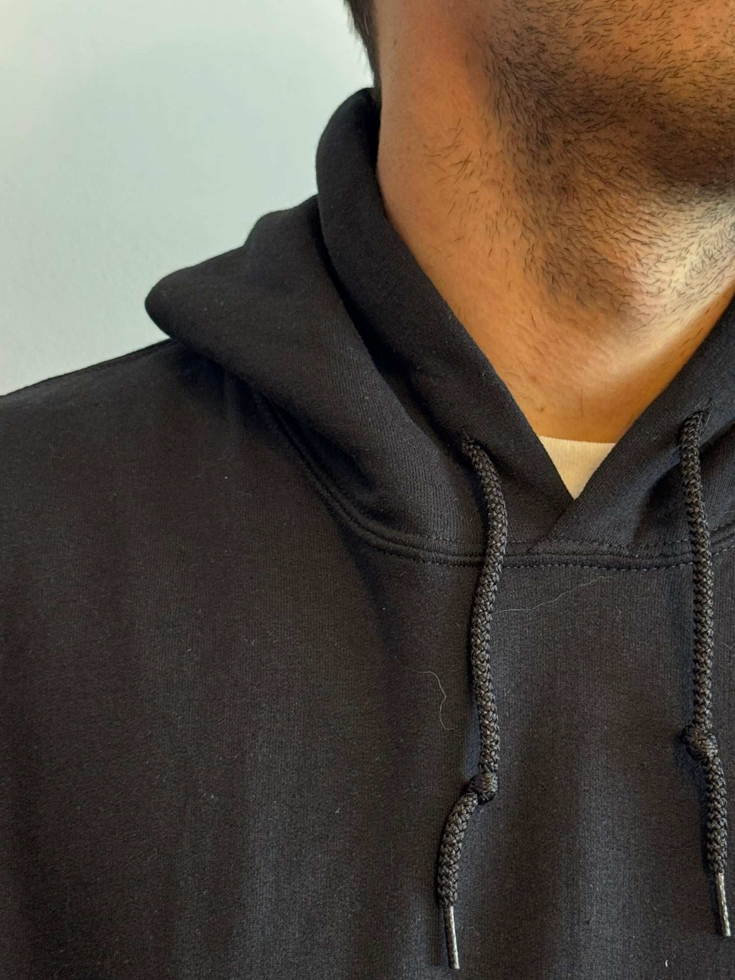 Close-up of a person wearing a black hoodie with a blurred background